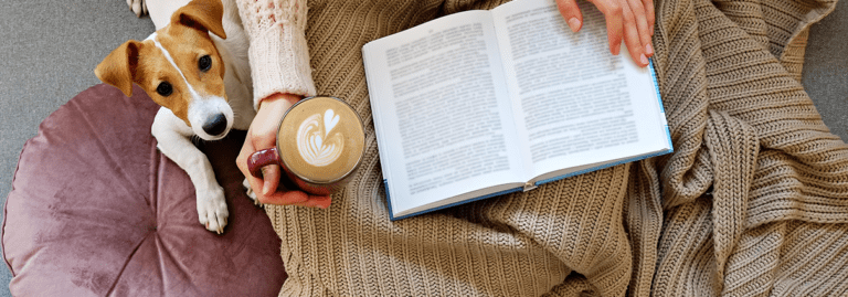 Woman practicing self care while reading a book with her dog | Limeade