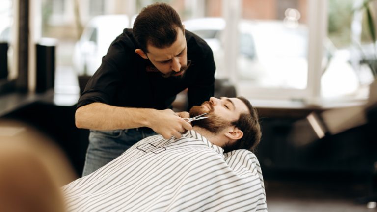 Barber trimming a man’s beard | What Profession Has the Lowest Burnout Rate? | Limeade