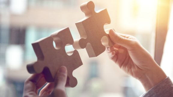 Proactive employee putting together two pieces of a puzzle | Limeade’s employee engagement program